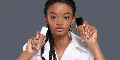 模特手持瓶装 Teint Idole Matte Foundation(无痕舒适粉底液)和 Teint Idole Care & Glow Foundation(无痕舒适调理和光泽粉底液)。