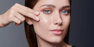 女性使用指尖在油性肌肤上涂抹粉底液