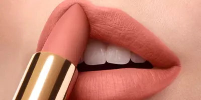使用裸色唇膏涂抹粉色唇彩的女士